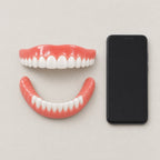 Snap-On Cosmetic Tooth Cover, Flexible Silicone Smile Cover for Photos & Events shown beside a smartphone for scale