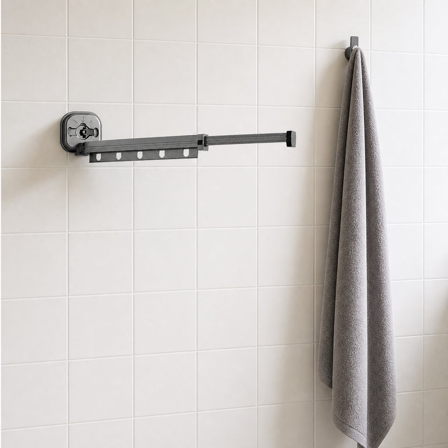 Suction Cup Drying Rack, No-Drill Telescopic Wall Rail for Laundry extended on a bathroom wall beside a hanging bath towel, for scale