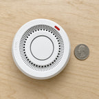 Smart WiFi Smoke & Fire Alarm, 85dB Heat Detection Alert with App Notifications, beside a US quarter coin for scale