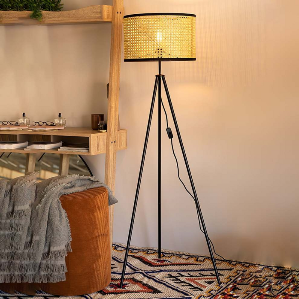 Boho standing floor lamp with handwoven wicker shade and modern tripod base studio view